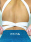 white sports bra with open back that has crossed straps and halter neckline in the back. in the front the top has a mesh panel.
